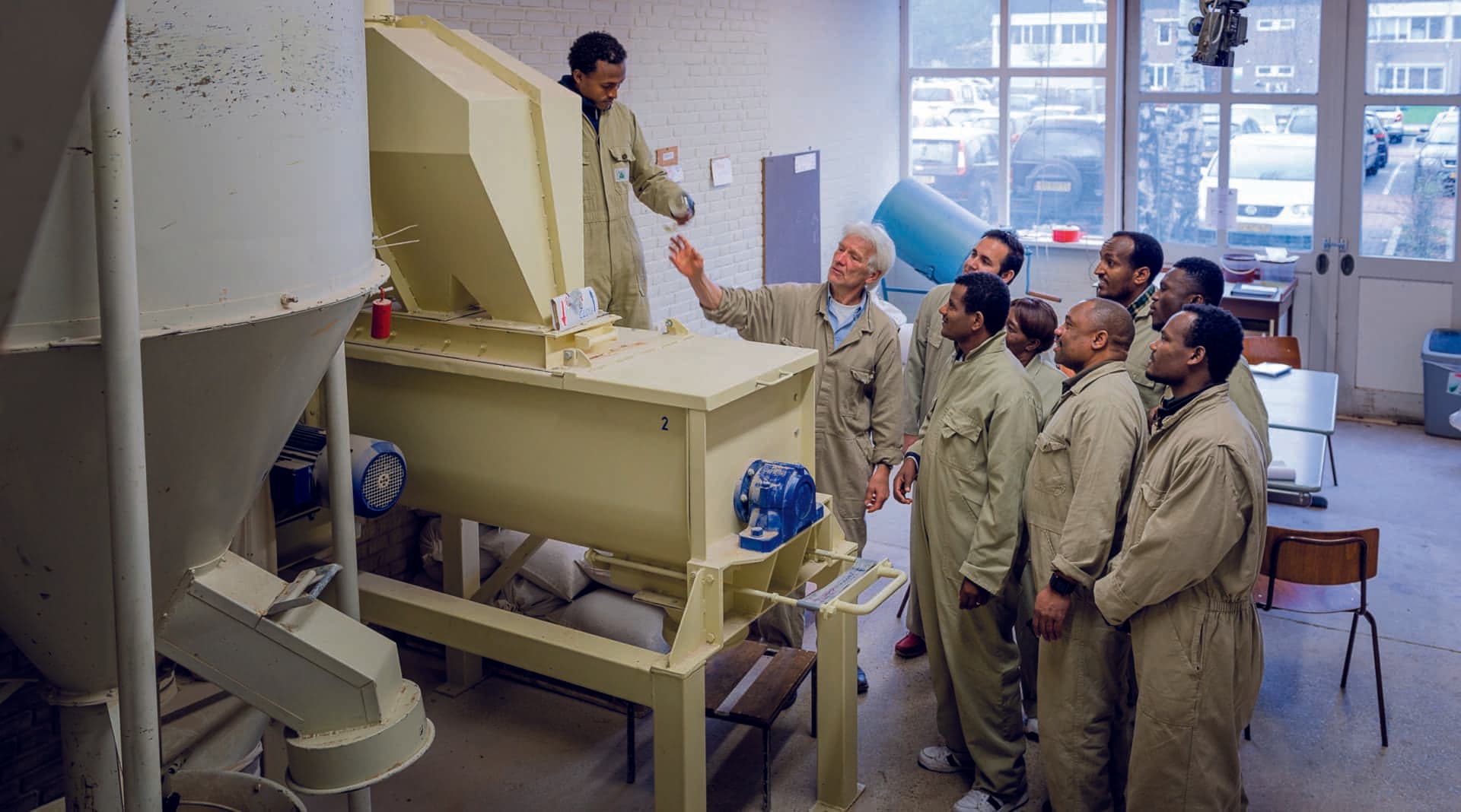 men in overalls checking out a machine