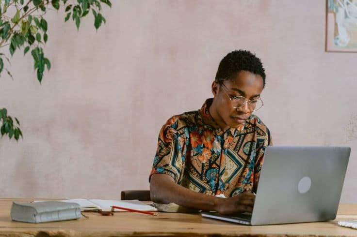 a person using a laptop and some books on the table