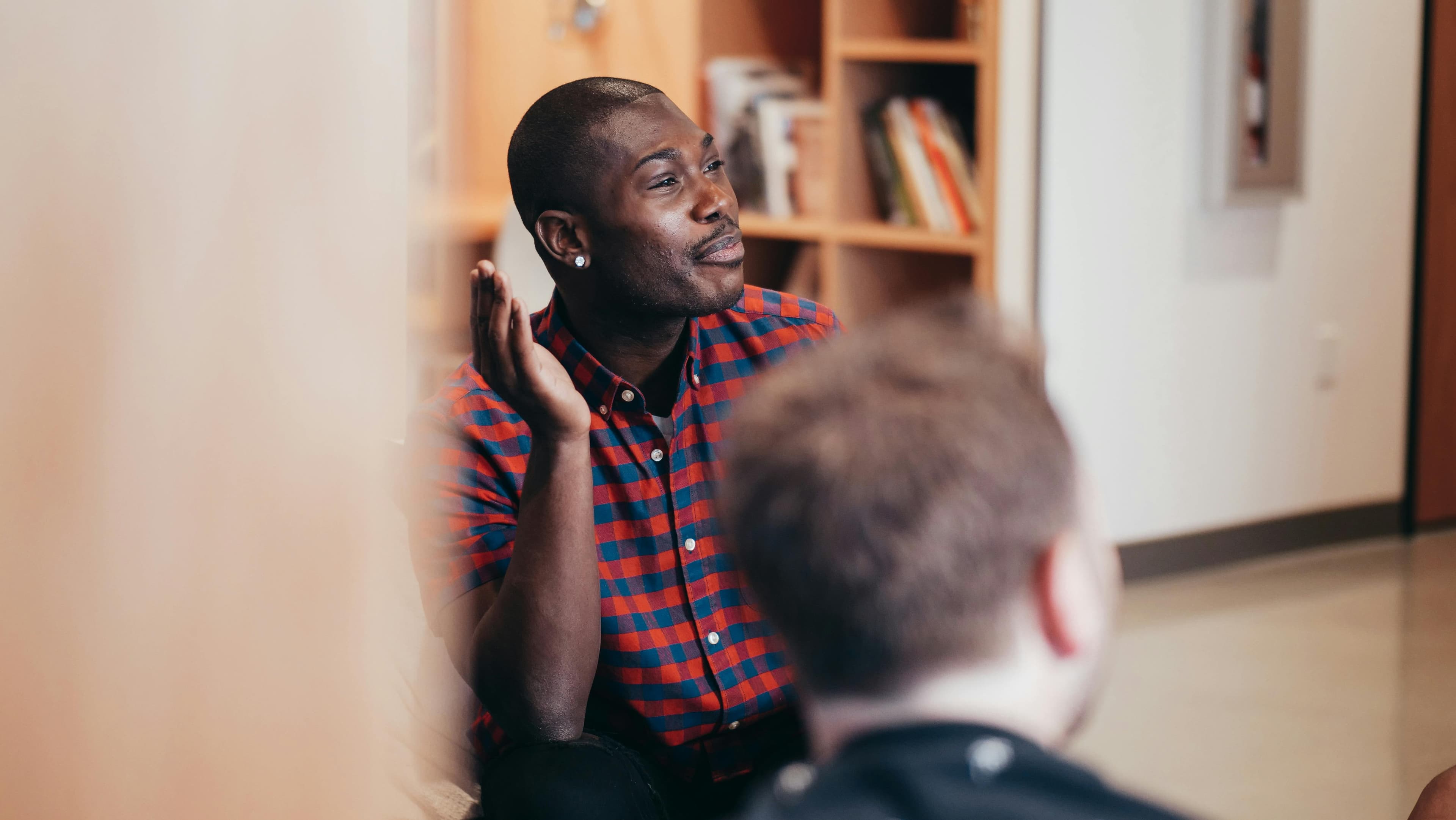 man in checkered shirt and earring